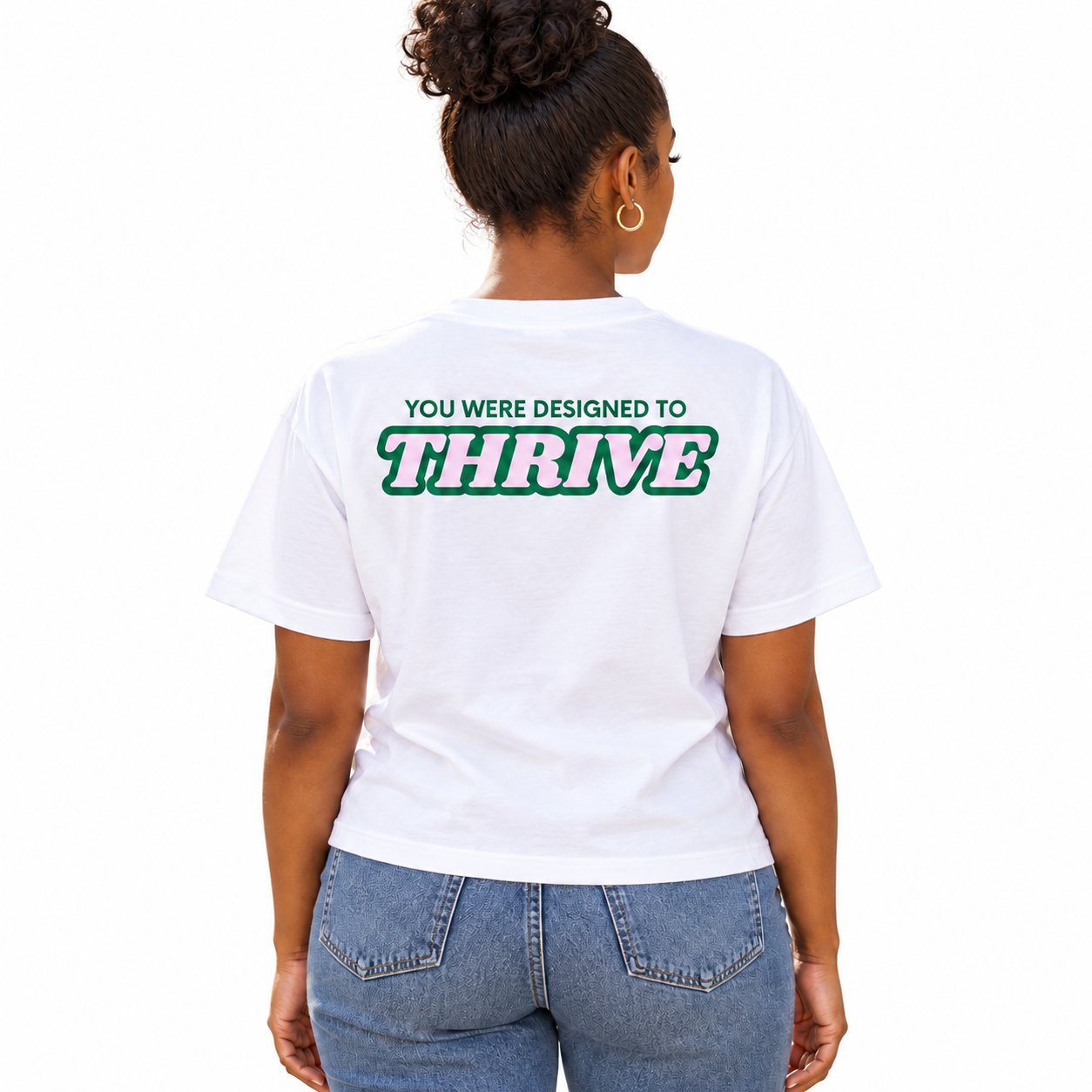 Back view of a white tee with You Were Designed to Thrive lettering in green and pink